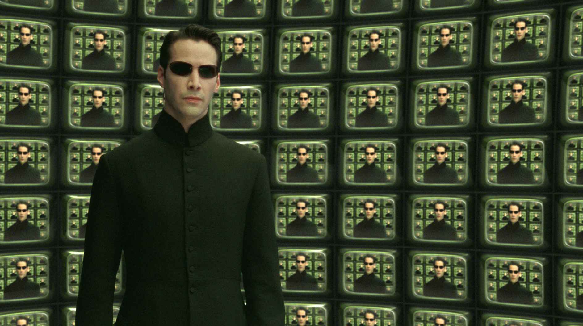 Neo stands in front of matrix of TVs